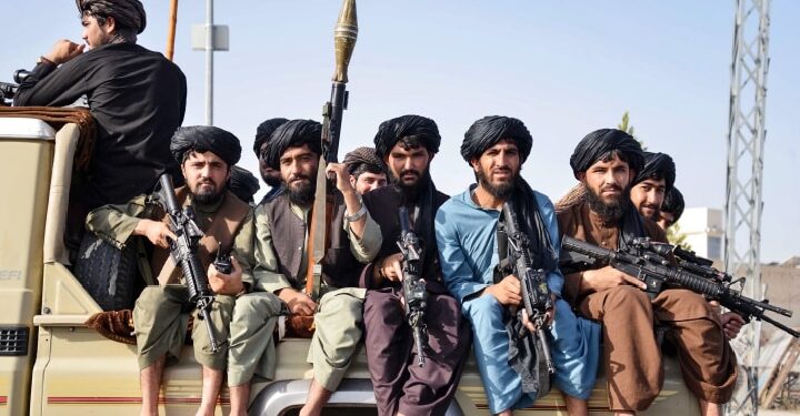 Taliban security personnel sit atop a military vehicle during a parade to celebrate the third anniversary of Taliban's takeover of the country in Kandahar August 2024