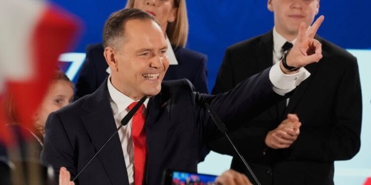 Karol Nawrocki greets supporters as he arrives at his headquarters after the presidential election run-off in Warsaw, Poland, June 1, 2025