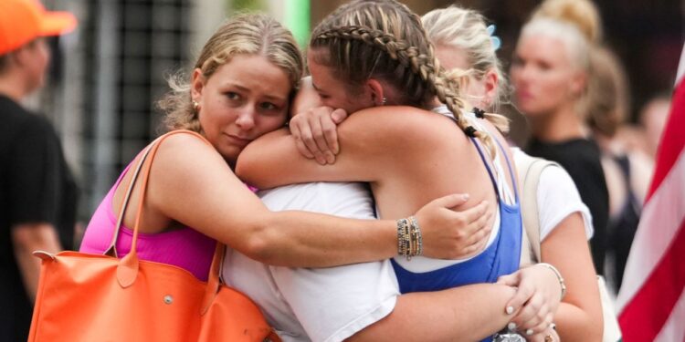 Campers embrace at a reunification area as girls from Camp Waldemar, near the north fork of the Guadalupe River are reconnected with their families on Saturday.