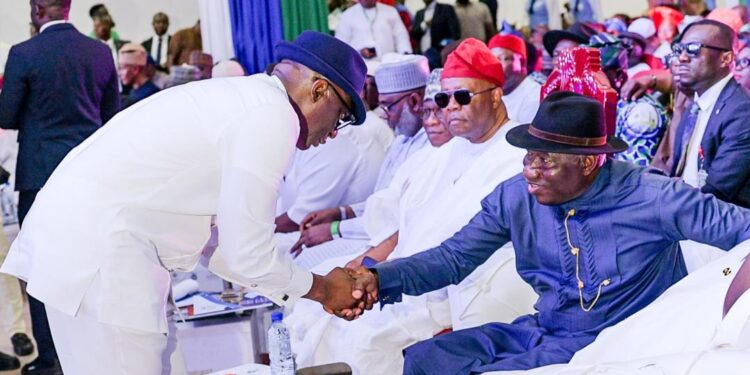 Chairman of the NDDC Governing Board, Mr. Chiedu Ebie (left), exchanges pleasantries with former President Dr Goodluck Jonathan( right), during the NDDC 25th Anniversary, Plenary Session, in Rivers State. In the middle is the Senate President, Chief Godswill Akpabio.