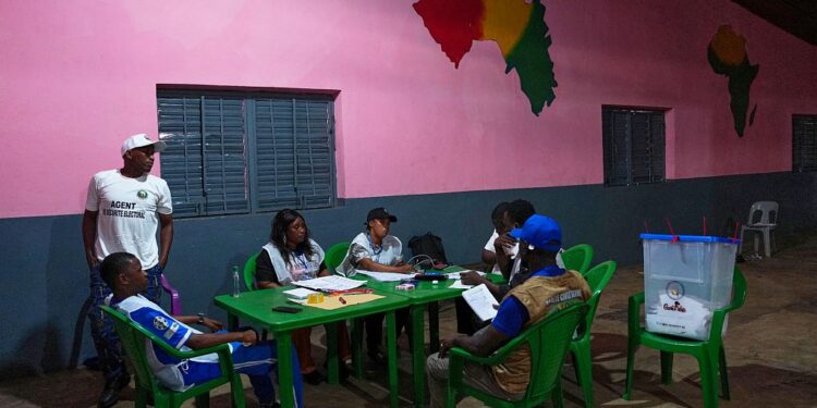 Officials wait at a polling station as polls close during the constitutional referendum in Conakry, Guinea, Sunday, Sept. 21, 2025