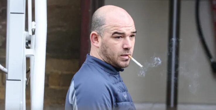Smith smoking a cigarette before being taken inside