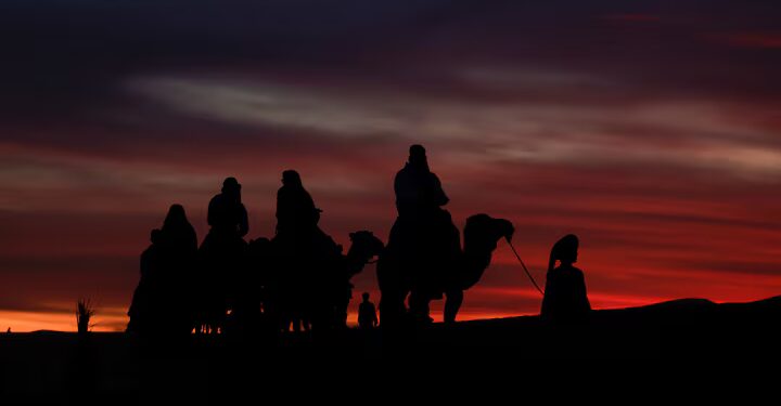 Tourists ride camels on the dunes at the Erg Chebbi sand dunes after sunset in the Sahara desert outside Merzouga, Morocco December 7, 2024
