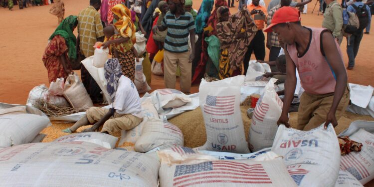 FILE - Workers distribute food aid from the World Food Program at a refugee camp in Dolo, Somalia on July 18. 2012. (AP Photo/Jason Straziuso, file)
