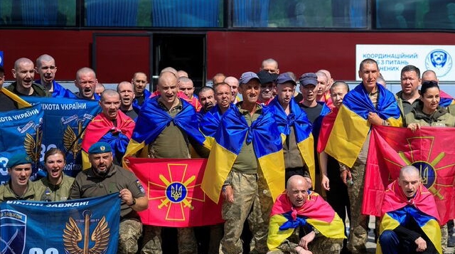 Ukrainian prisoners of war (POWs) shout slogans while they pose for a picture after a swap, amid Russia's attack on Ukraine, at an undisclosed location in Ukraine August 19, 2026